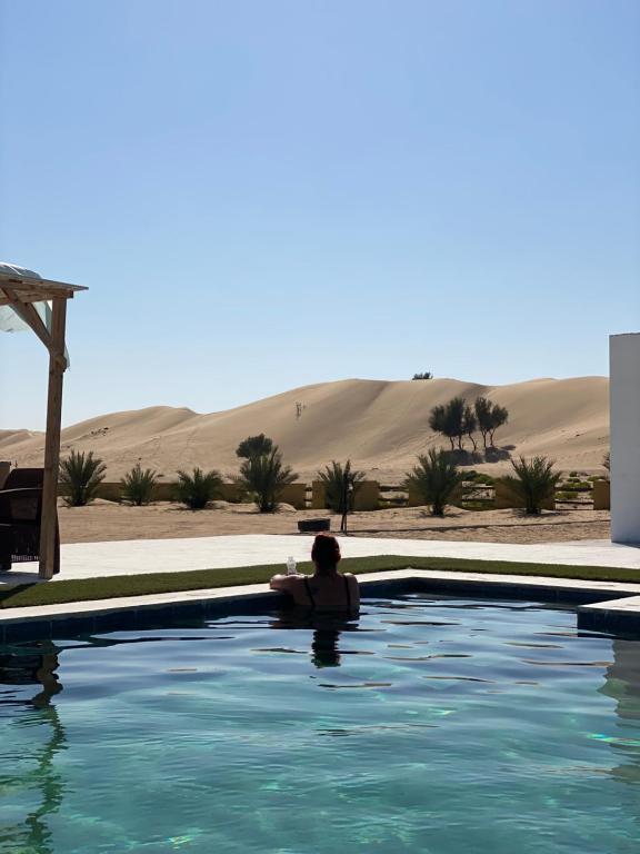 Fulayj al Mashāʼikh金棕榈绿洲酒店的坐在沙漠游泳池里的人