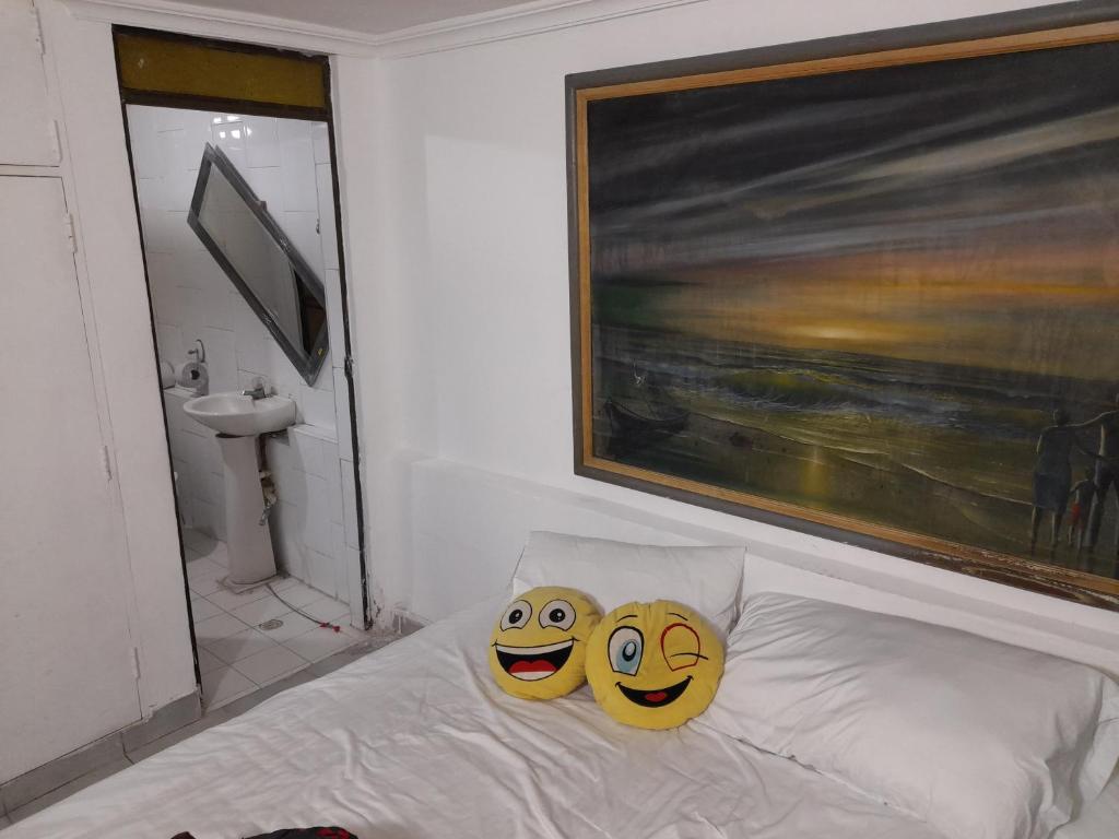 卡塔赫纳Hostal Tosty的卧室的床上配有两个微笑枕头