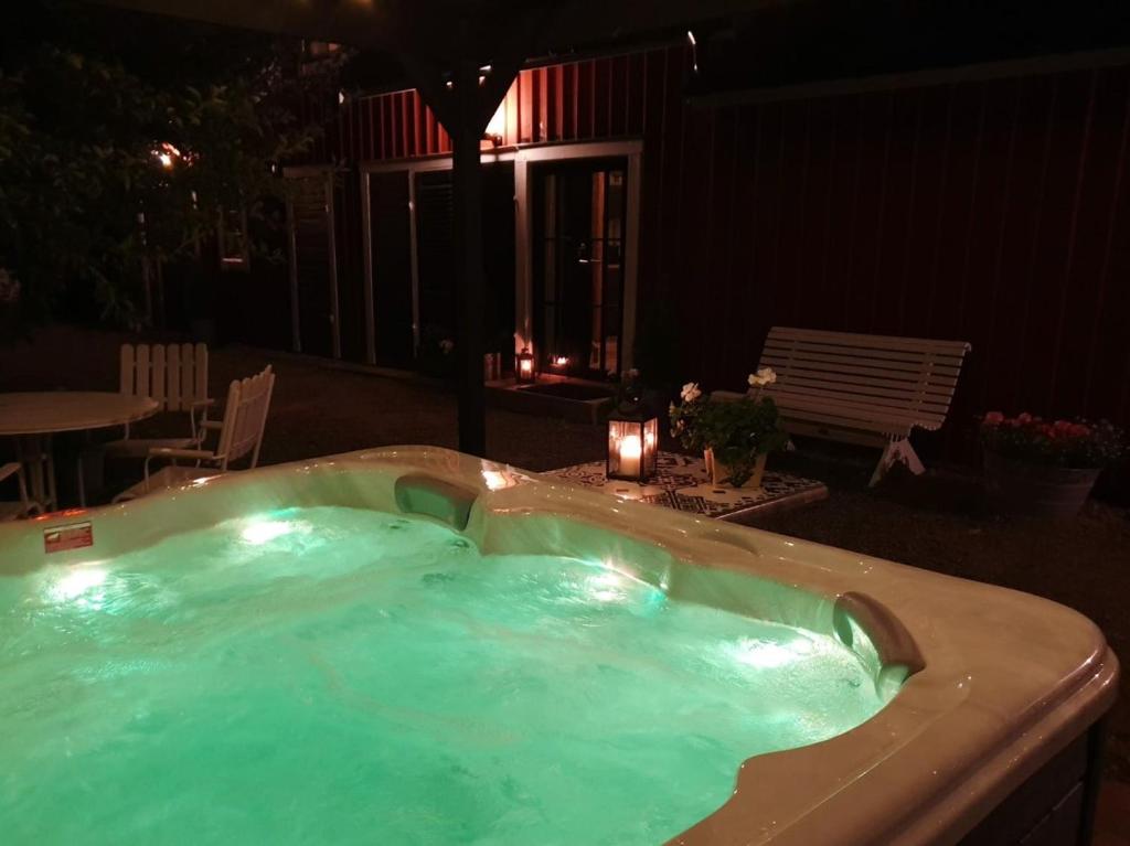 瓦斯泰纳Gårdshus med spabad utomhus的晚上在后院的热水浴池