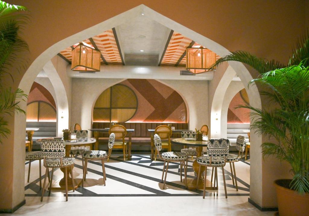 斋浦尔Bur'Dera - a Boutique Luxury Hotel的一间在房间内配有桌椅的餐厅