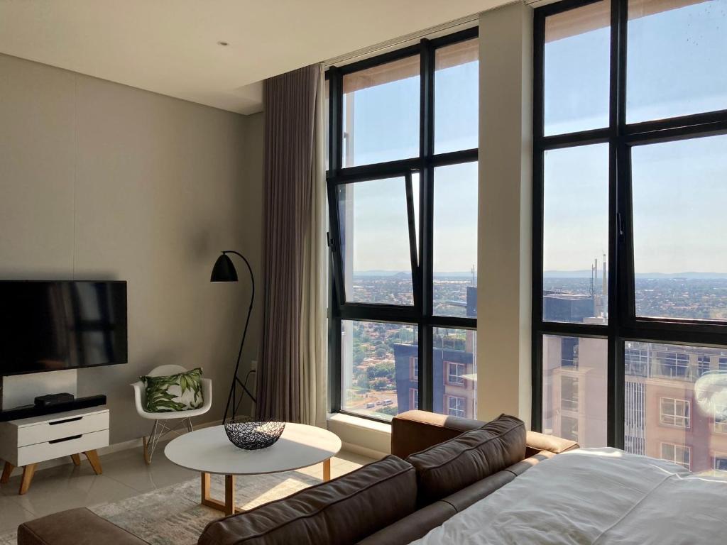 哈博罗内Urban Awe Apartment: iTowers 21st Floor的带沙发和大窗户的客厅