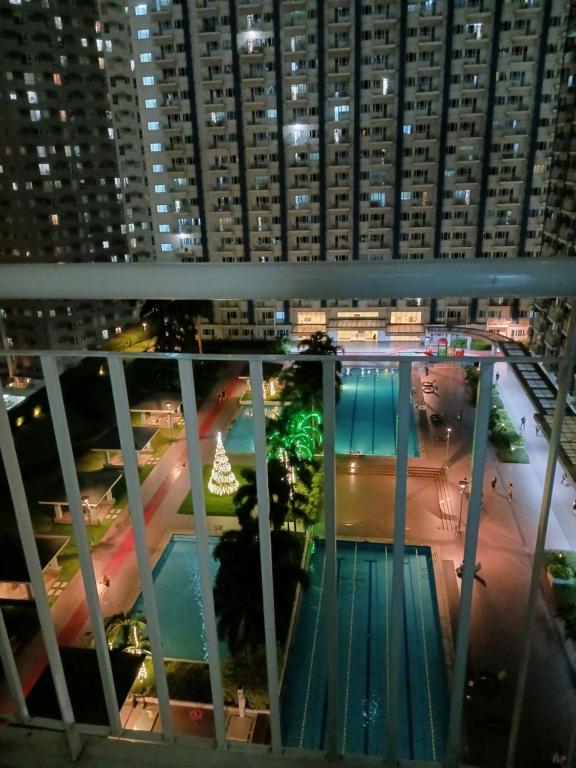 马尼拉1 BR with poolside view balcony的享有游泳池的夜间景致