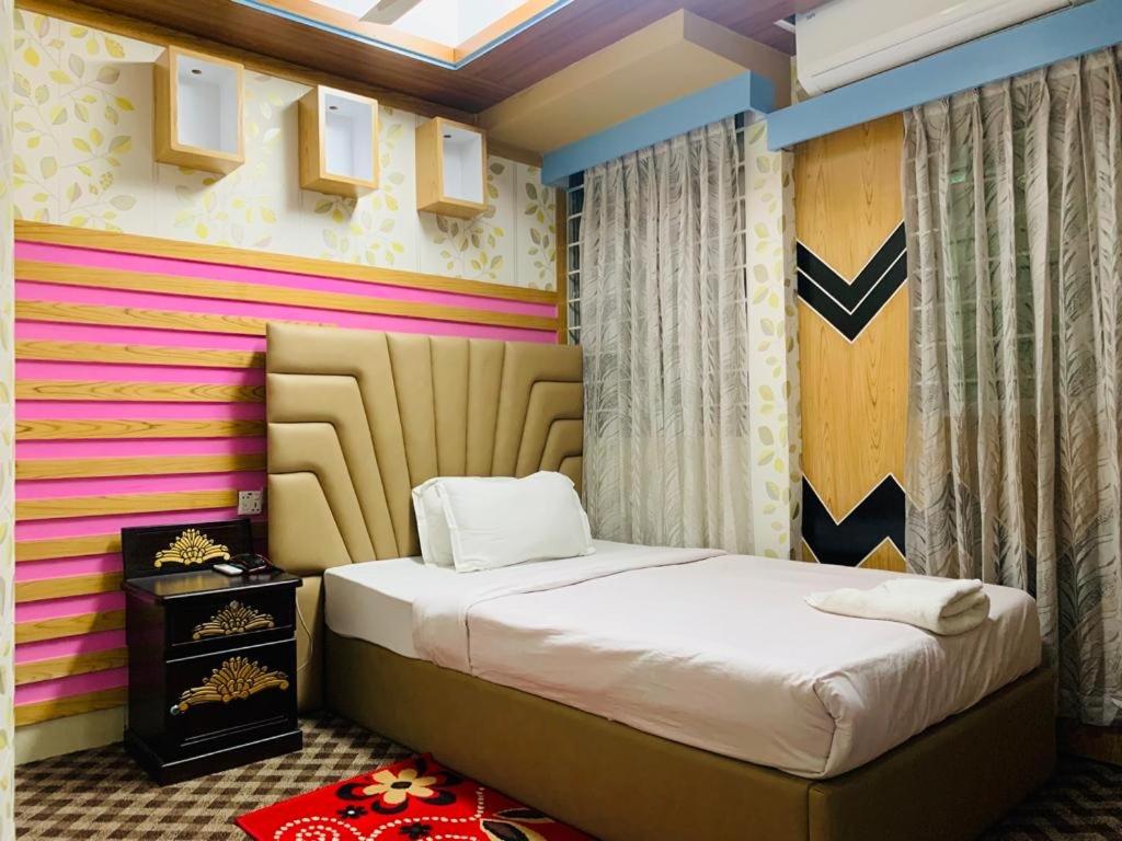 达卡Hotel Heaven Inn的一间卧室设有一张床和色彩缤纷的墙壁