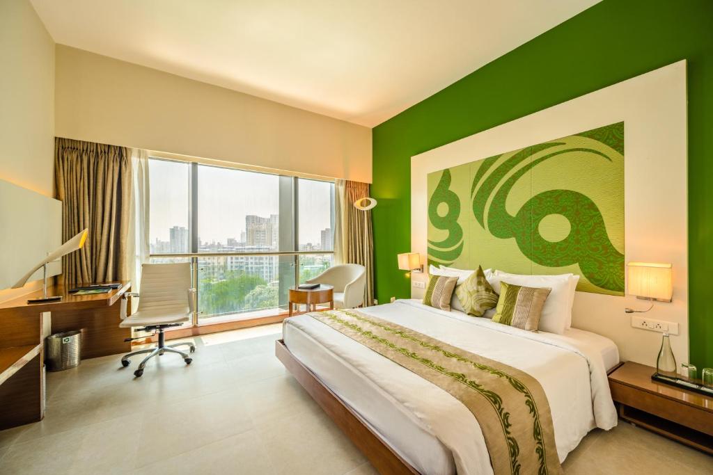 孟买蕨类植物住宅酒店的一间卧室设有一张大床和绿色的墙壁