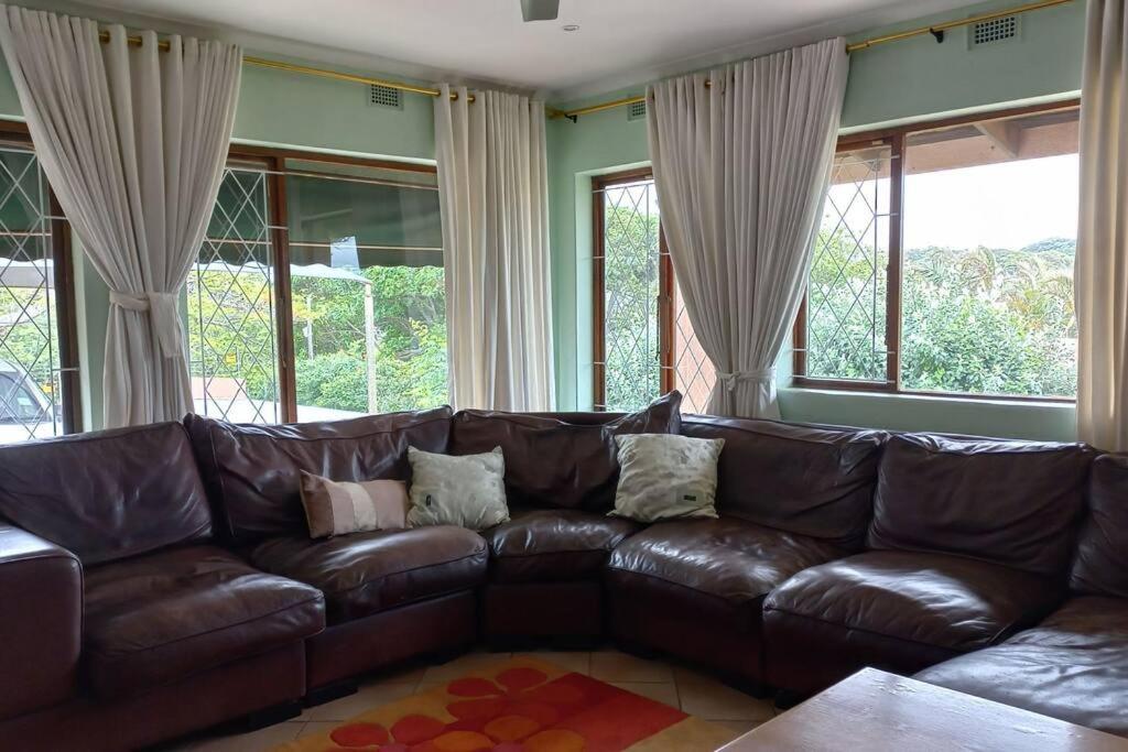 KingsboroughGuest house Winklespruit的客厅设有窗户,配有棕色皮沙发