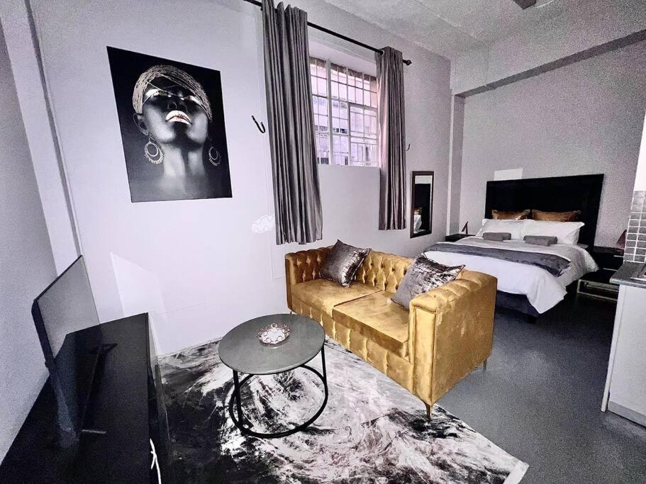 约翰内斯堡`Luxury Cosy City Apartment的客厅配有沙发和1张床