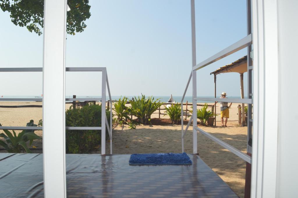 阿贡达Riya Cottages and Beach Huts的通往带秋千的海滩的开放式门