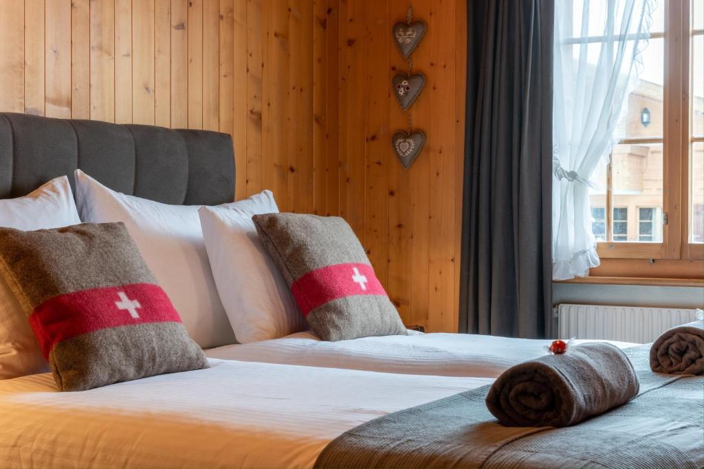 格施塔德Cozy Place in Gstaad center的一间卧室配有两张带枕头的床和窗户。