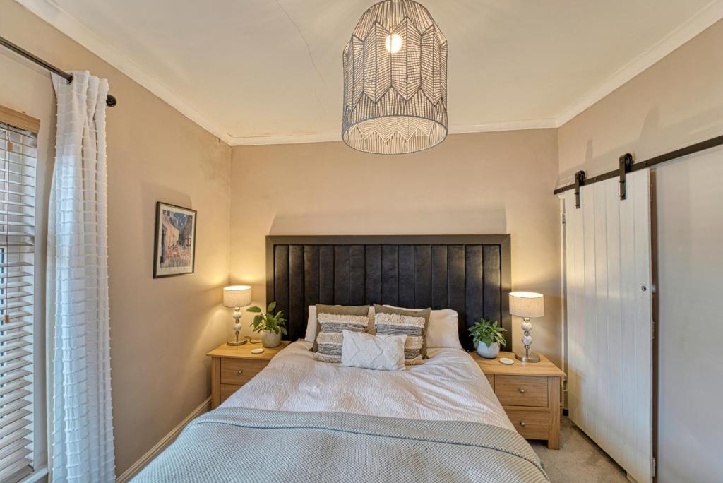 莱斯特Guest Homes - Loughborough Road House的一间卧室配有一张大床和一个吊灯。