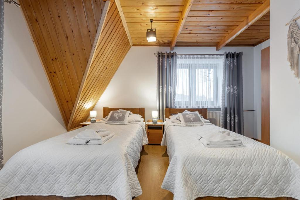 布泽吉Villa Kucówka的配有木天花板的客房设有两张床。