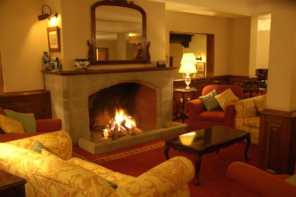 NkoanruaArusha Serena Hotel的客厅设有壁炉、沙发和镜子