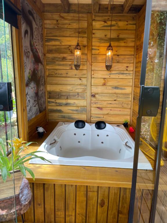 蒙特韦尔迪Recanto Lira II的木结构客房的按摩浴缸,配有灯光