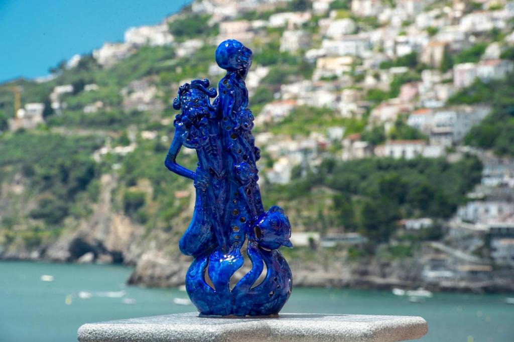 弗洛里La Perla di Nettuno的女人和猫的蓝色玻璃雕像