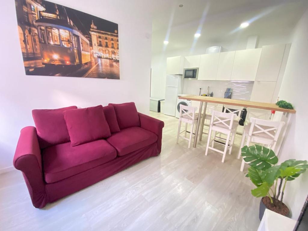 塞图巴尔Gama Apartment的一间带紫色沙发的客厅和一间厨房