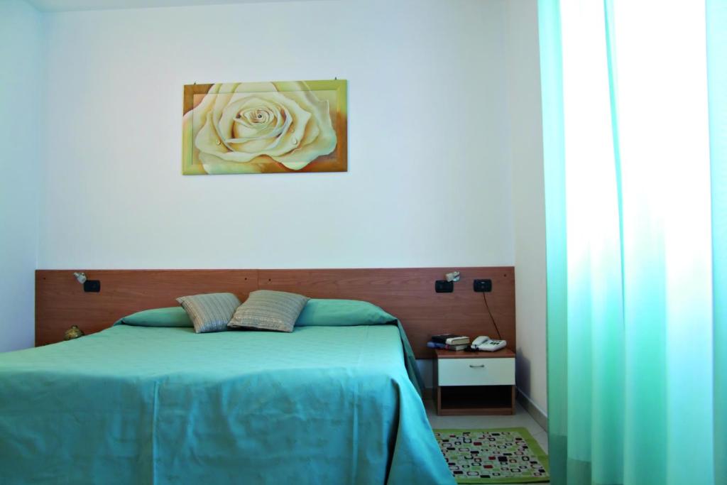 洛阿诺Residence La Casetta的一间卧室配有一张蓝色的白色玫瑰床