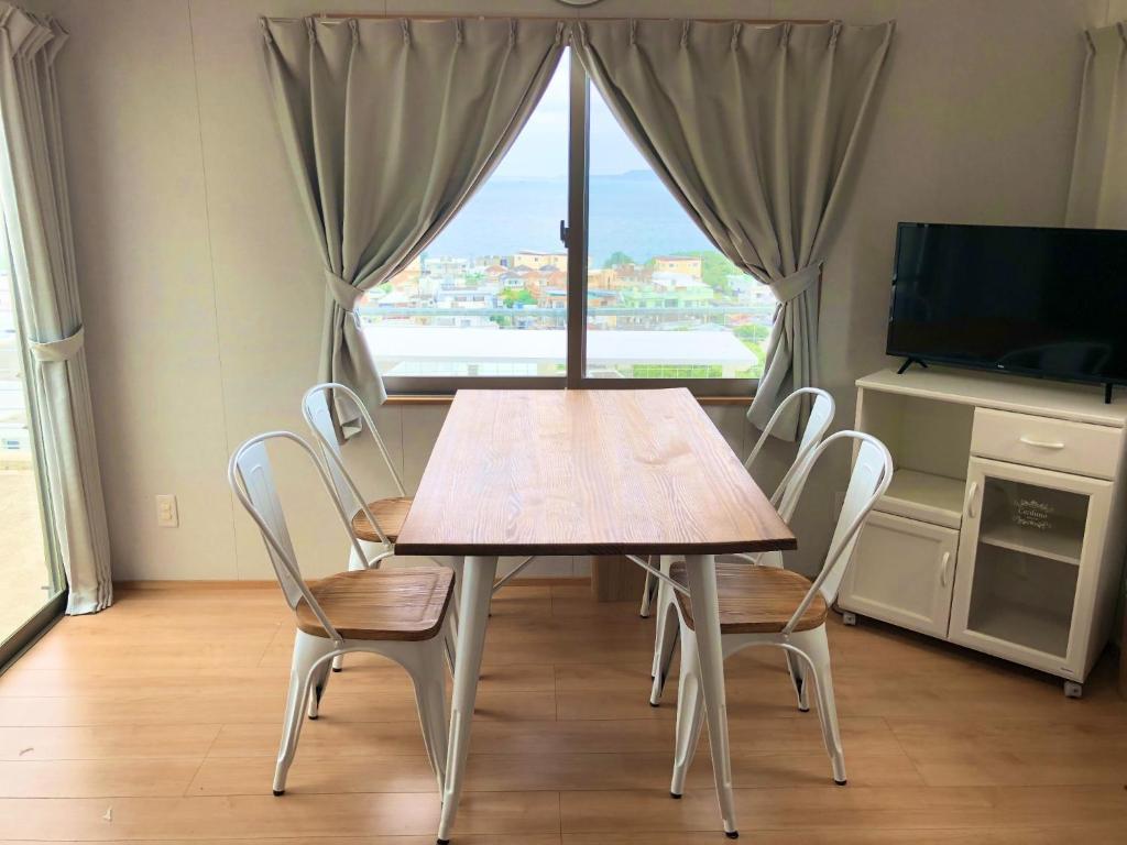 宇流麻Guest House Marine View - Vacation STAY 62152v的窗户客房内的桌椅