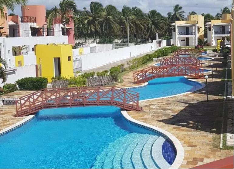 马拉卡贾Paraiso de Maracajau的度假村内一座带桥梁的游泳池