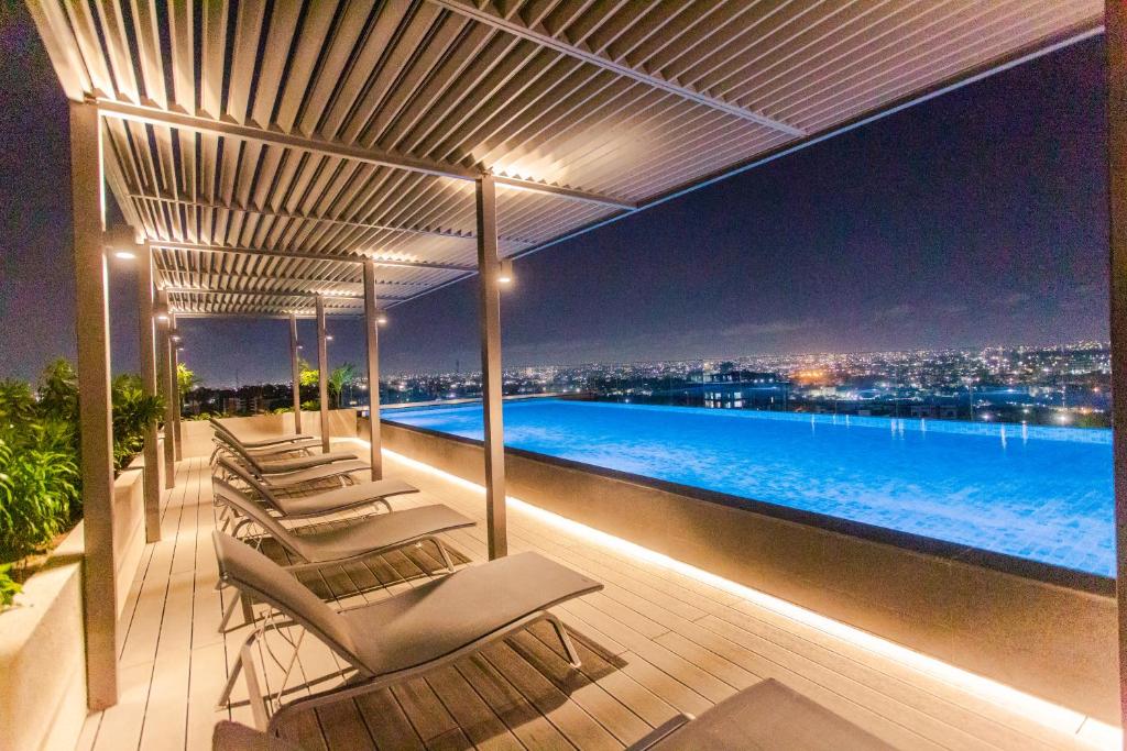 阿克拉Accra Luxury Apartments @ The Lennox的一个带躺椅的甲板和夜间游泳池