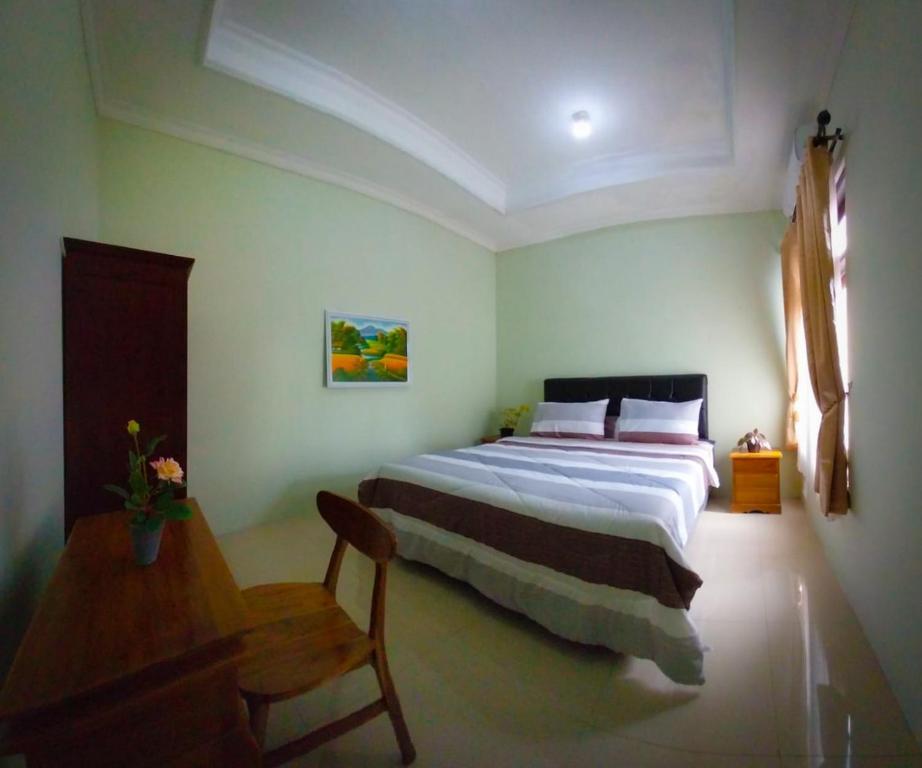 日惹Gated 3BR Residence - 10 mins from Malioboro的一间卧室配有一张大床和一张木桌