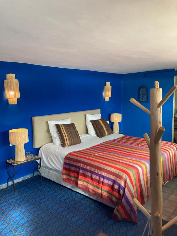 拉拉塔可库斯特Le Patio Du Lac的一间卧室配有一张蓝色墙壁的床