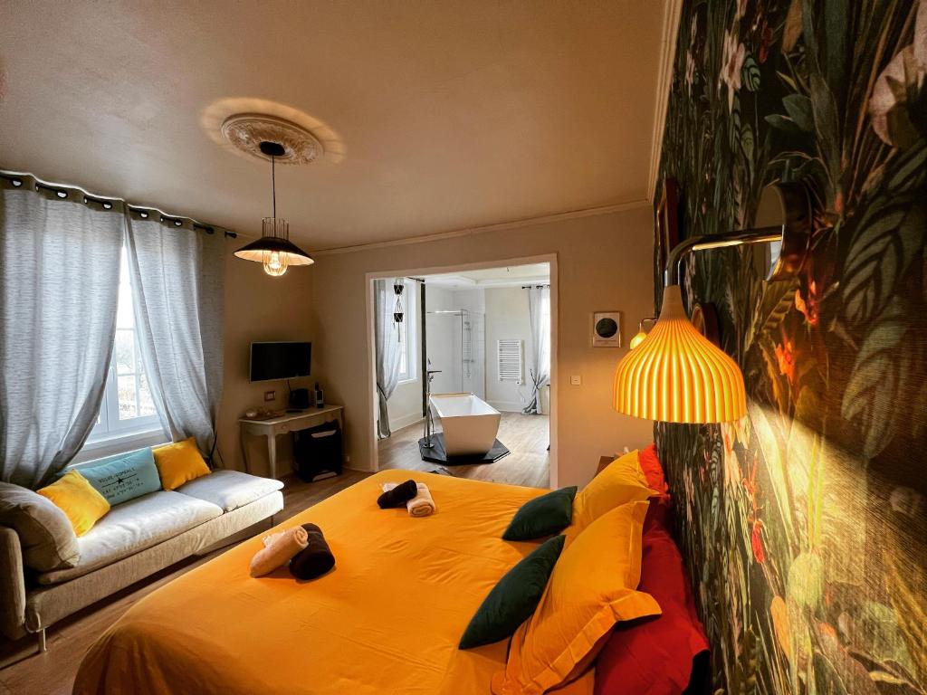 杜河畔凡尔登L'ESCALE Chambres et table d'hôtes的一间卧室配有一张黄色的大床和一张沙发