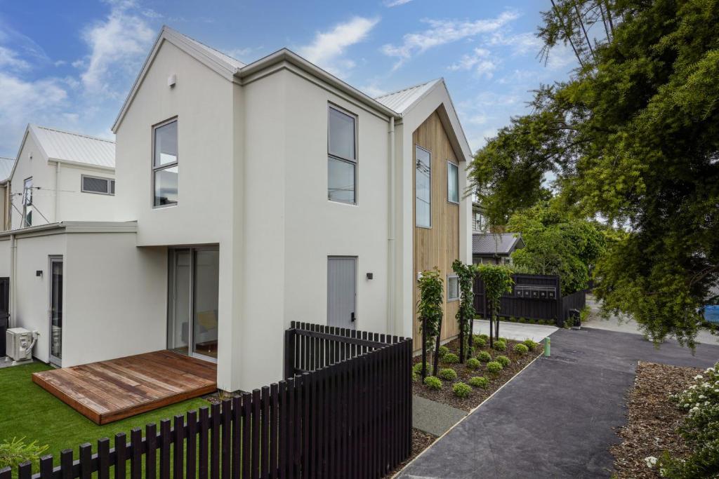 基督城Addington Delight - Christchurch Holiday Home的白色的房子,有黑色的围栏