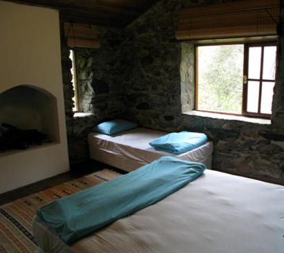 zerguz camping的石屋设有2个窗户,卧室配有2张床