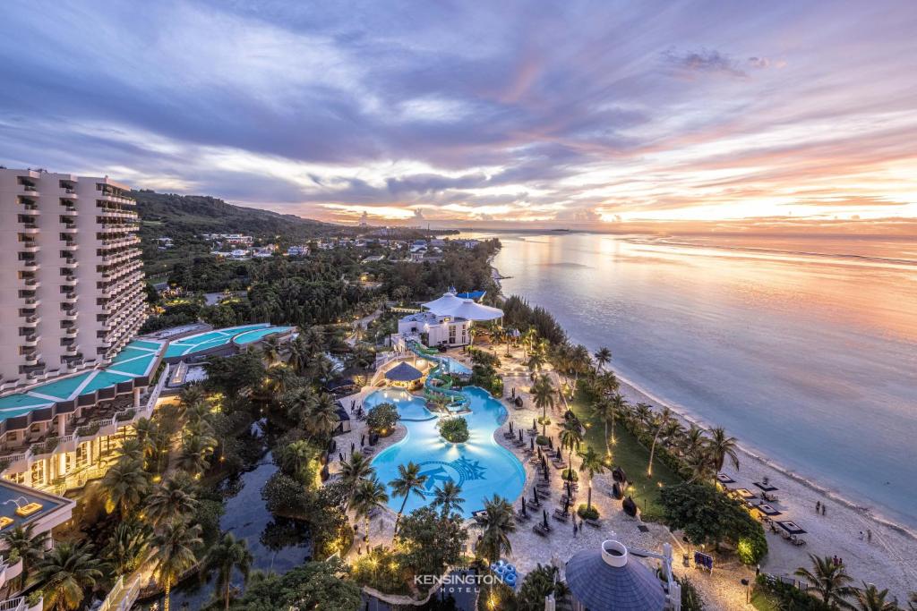 圣罗克Kensington Hotel Saipan的日落时分享有度假村和海滩的空中景致