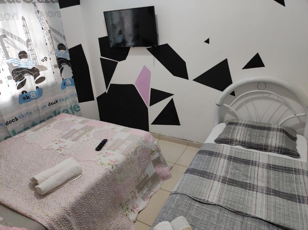 马瑙斯Romulo Ap的一间设有床铺和墙上电视的房间