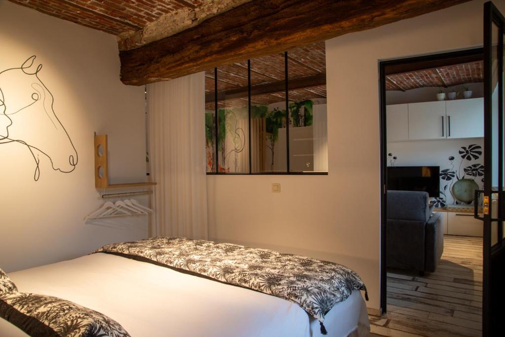 让布卢Le Relais de la Posterie的一间卧室设有一张床和一间客厅。