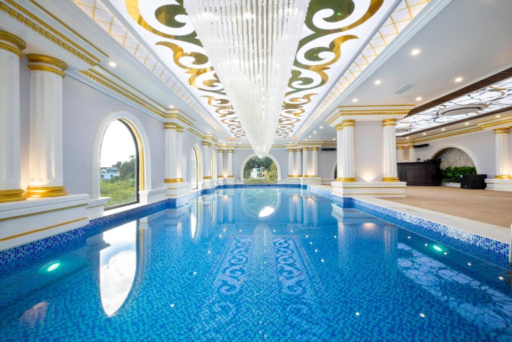 木州县Glenda Tower Moc Chau Hotel的一个带吊灯天花板的大型游泳池