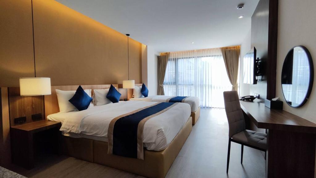 清迈Hi Chiangmai Hotel的酒店客房设有一张大床和一张书桌。