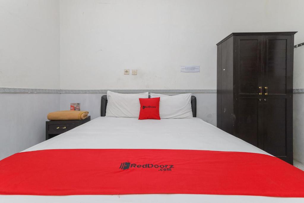 玛琅RedDoorz near Stasiun Malang Kota Lama 2的床上有红色枕头