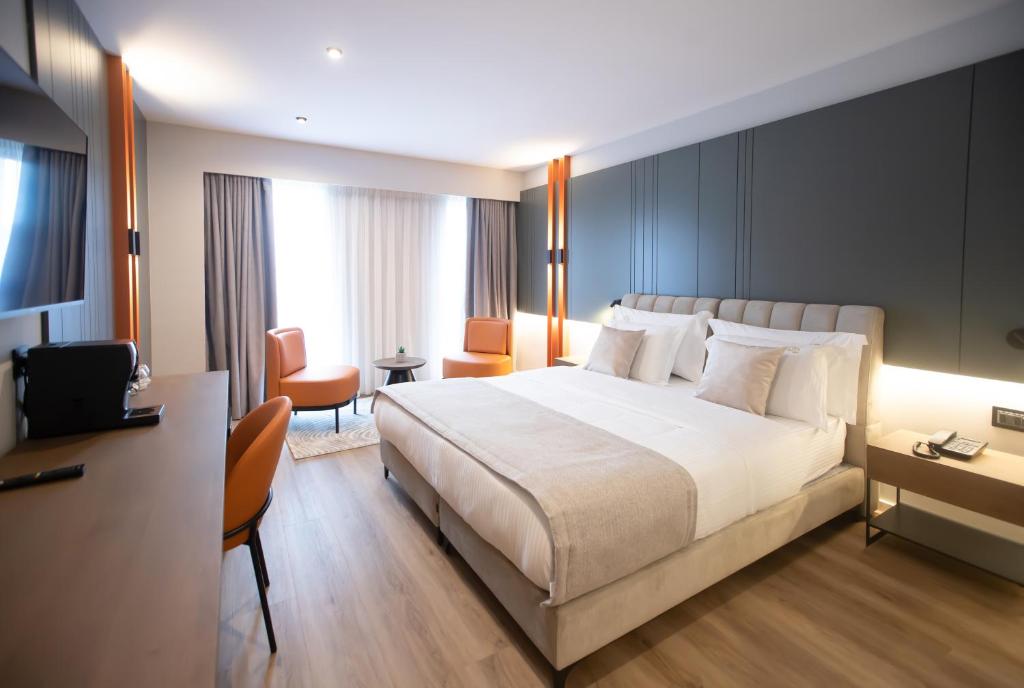 地拉那Hotel Elisa Tirana, Affiliated by Meliá的酒店客房设有一张大床和一张书桌。