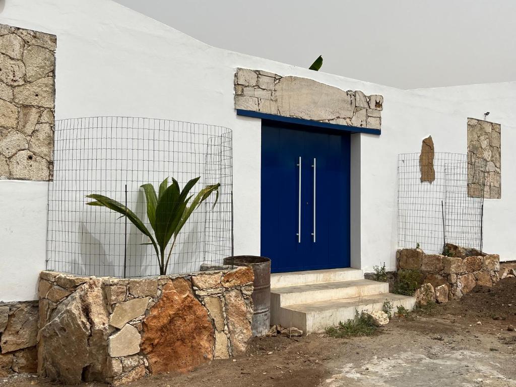 马约城Quintal do Maio的白色建筑一侧的蓝色门