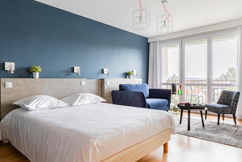LʼHorme伏尔甘酒店的一间卧室设有一张床和蓝色的墙壁