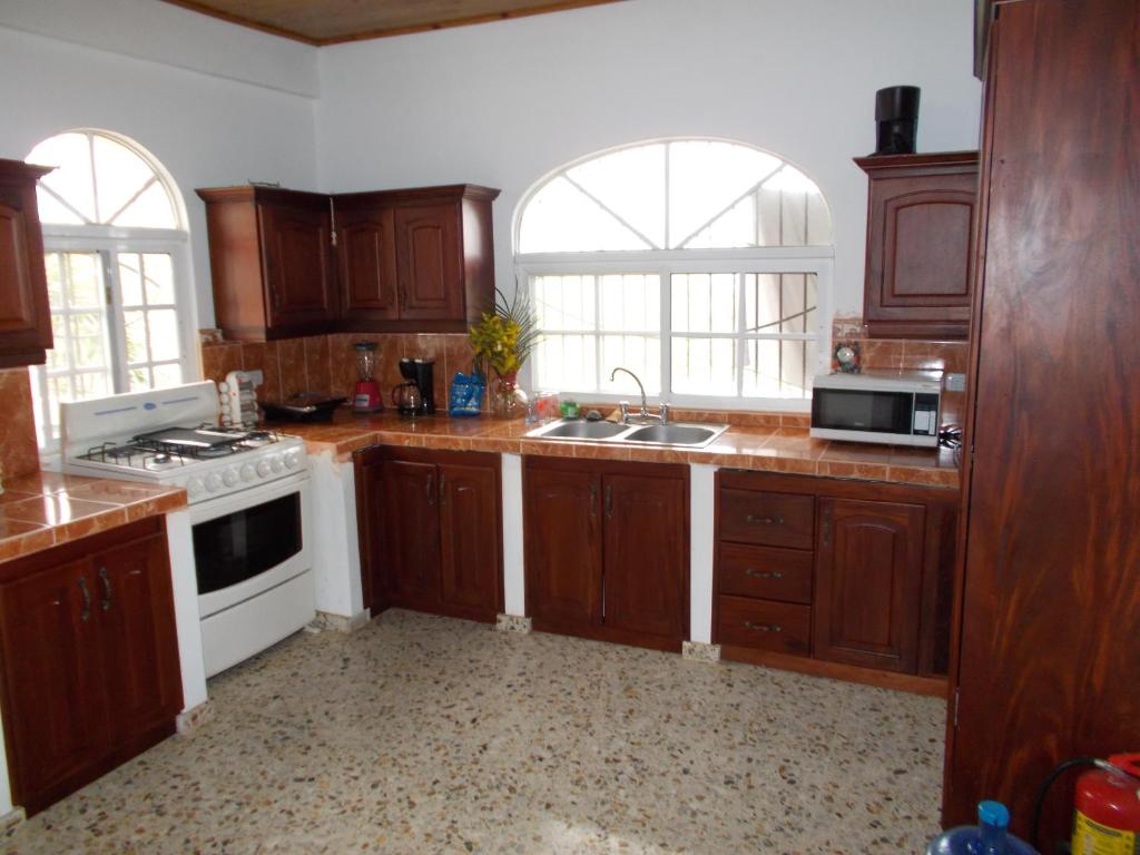 拉斯特拉纳斯卡斯蒂略罗曼诺旅馆的厨房配有木制橱柜和白色炉灶烤箱。