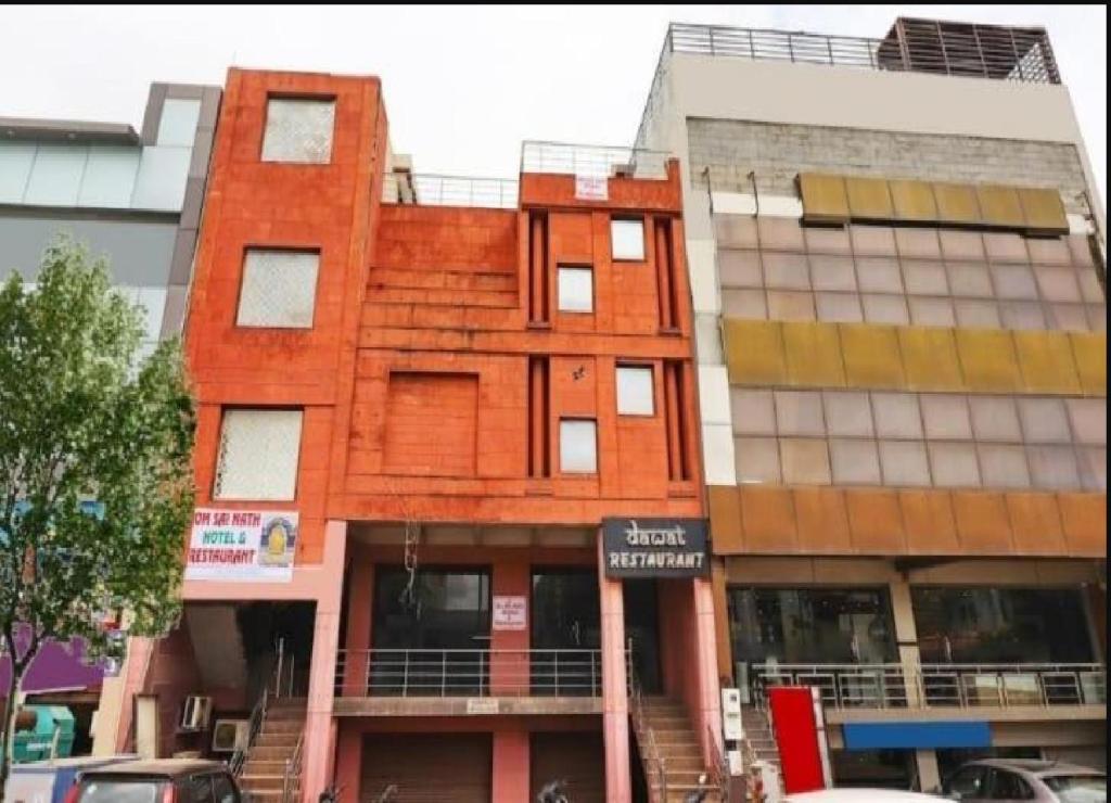 阿格拉Om Sai Nath Hotel & Restaurant By WB Inn的前面有标志的红色建筑