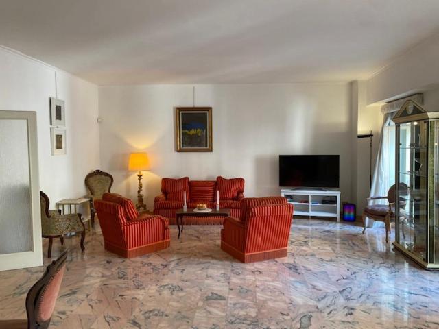 罗马VHOMETREVI的客厅配有红色椅子和平面电视