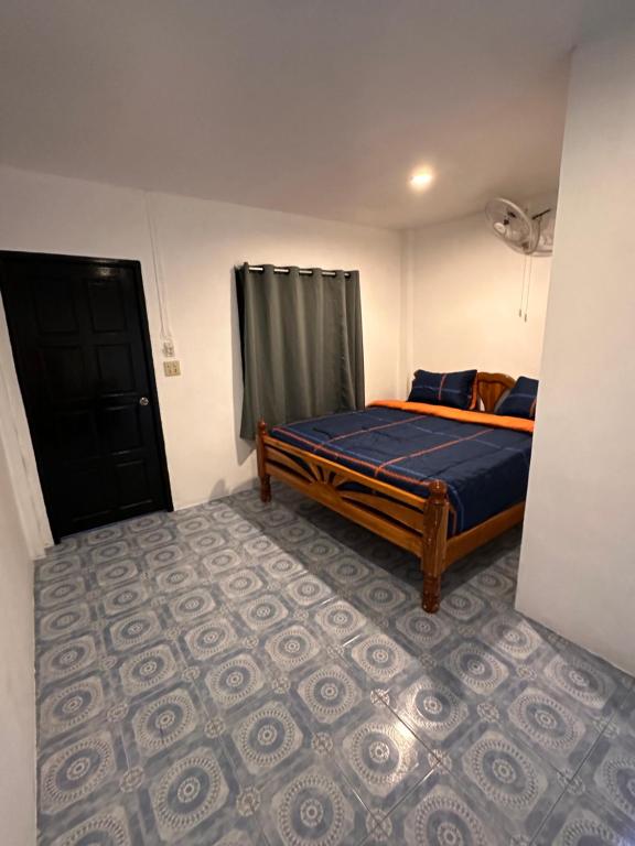 涛岛Divers House的一间卧室配有一张带蓝色棉被的床