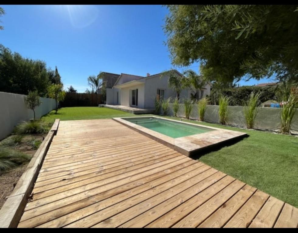 弗雷瑞斯Villa Junna的后院设有木甲板和游泳池