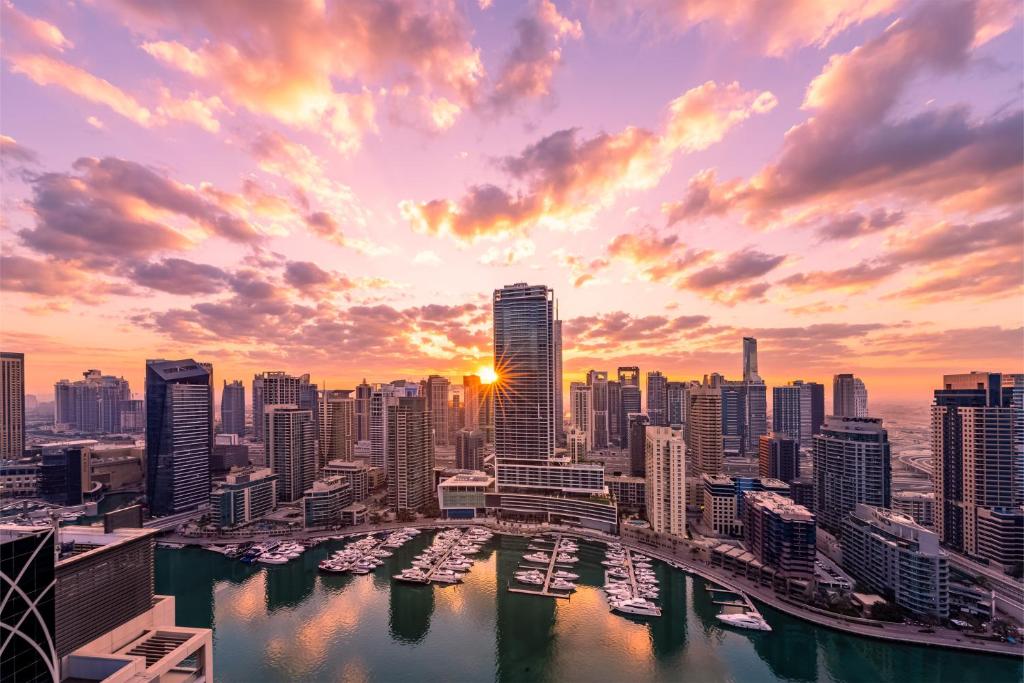迪拜迪拜码头及游艇俱乐部葳达酒店的日落时分的城市天际线,水中泛舟