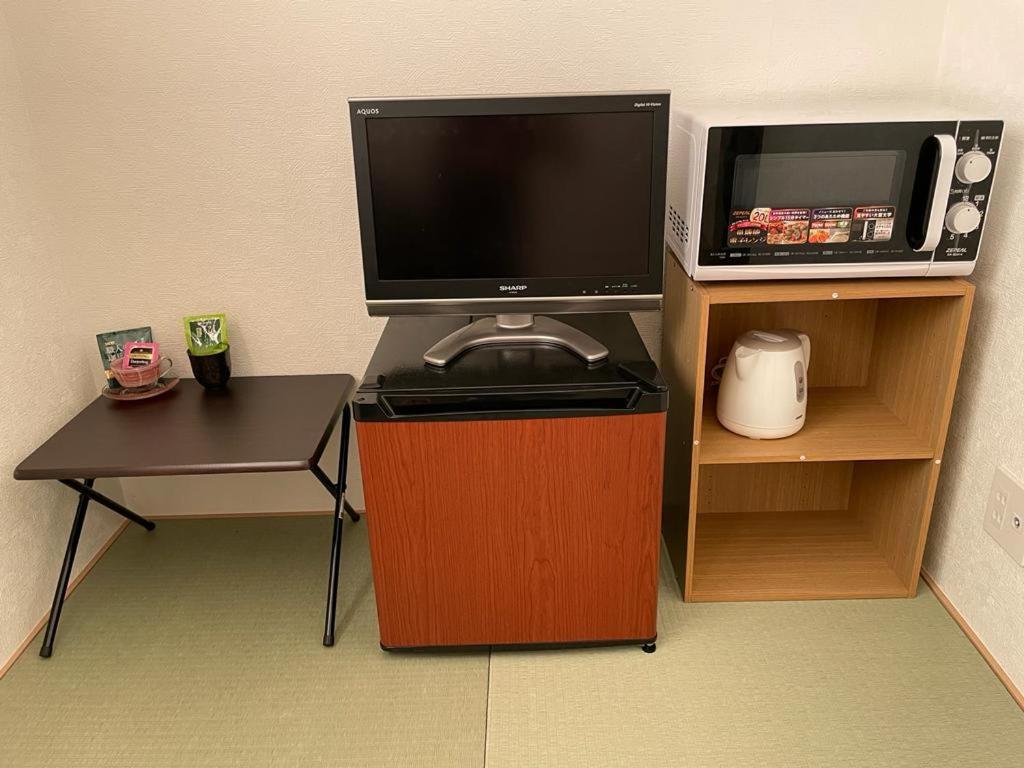 东京Bessalov Home Japanese style room的台上电视机,配有书桌和微波炉