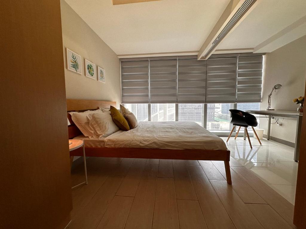 马尼拉Uptown BGC Luxury 1br Suite with Fast Wifi的一间卧室设有一张床和一个大窗户