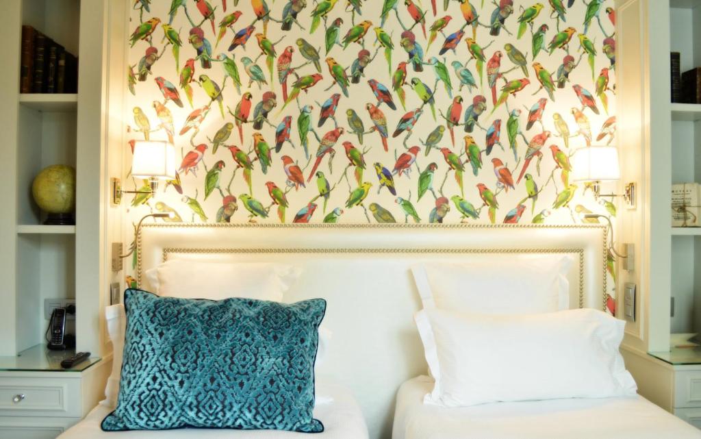 巴黎蒙赫酒店的一间卧室配有一张鸟壁纸床