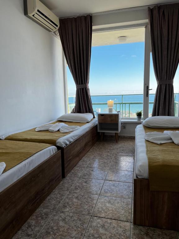 金沙Hotel Varshava的一间带两张床的卧室,享有海景