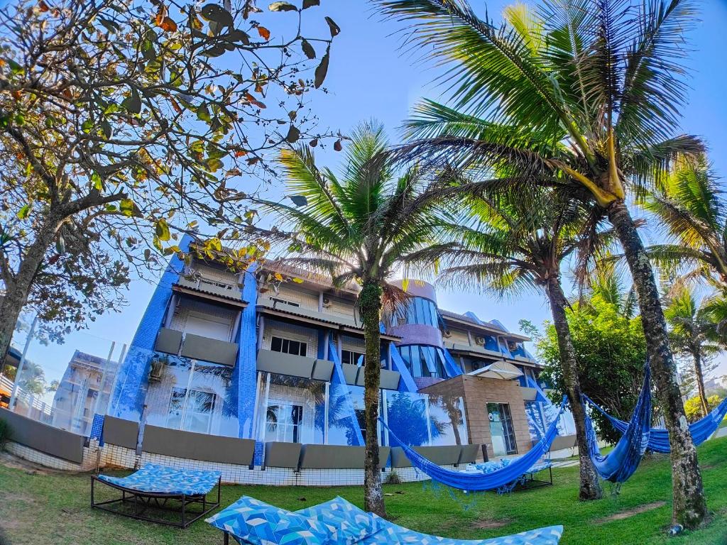 瓜拉图巴Spazio Marine Hotel - Guaratuba的棕榈树酒店前方设有吊床