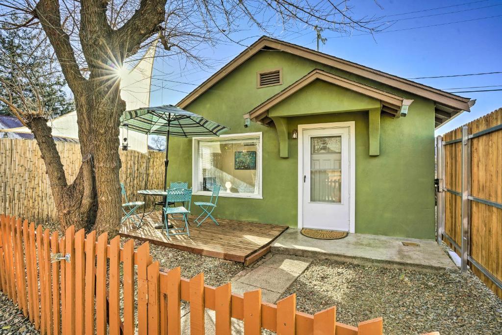 普雷斯科特Vibrant Prescott Cottage with Private Backyard!的绿色房子,配有桌子和围栏