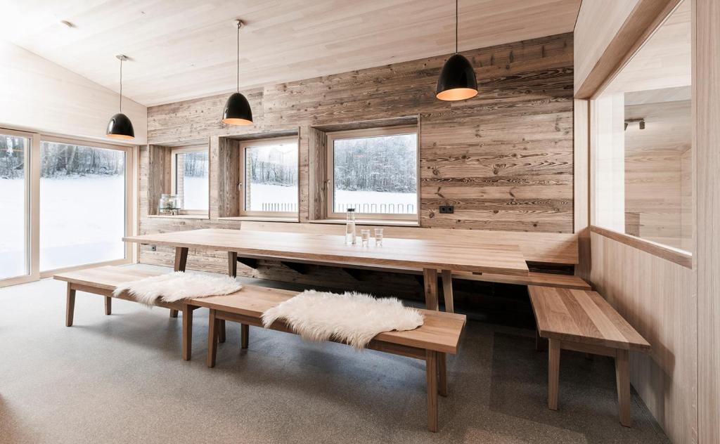 梅劳Ferienhaus Schihütte Mellau的一间带木桌和长凳的用餐室