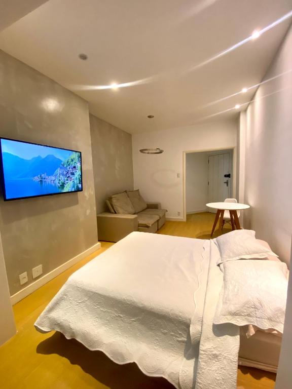 里约热内卢Apartamento Encantador Leme - Prédio na Orla的卧室配有白色的床和平面电视。